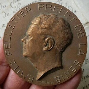 Puede incluir: Una medalla de bronce con la inscripci&oacute;n "Emile Pelletier Prefet de la Seine" y el nombre "A. Courbier" en la parte inferior.