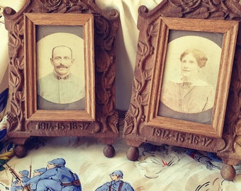 Puede incluir: Dos marcos de fotos antiguos de madera con detalles florales tallados. Cada marco contiene una fotografía en blanco y negro de una persona. Los marcos están fechados "1914-15-16-17".