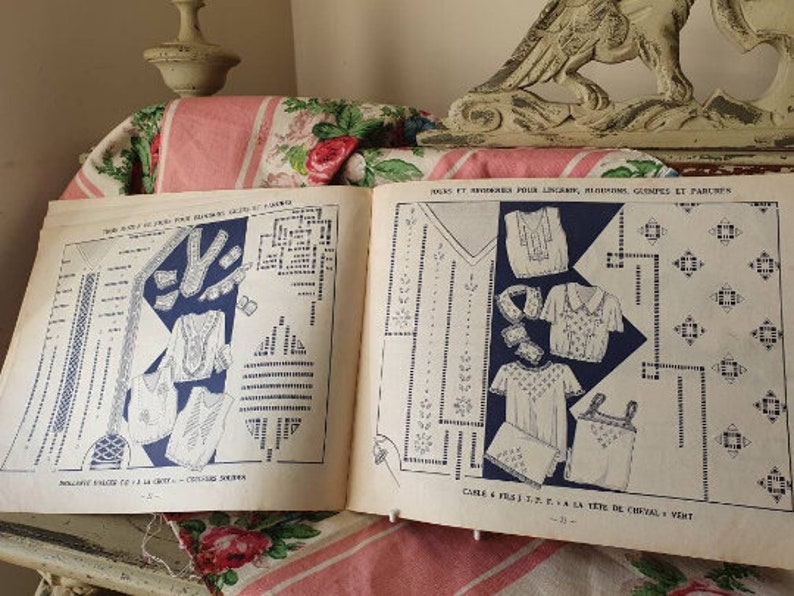 Peut inclure: Un livre vintage avec des instructions pour r&eacute;aliser des dentelles, des broderies et d'autres projets de broderie. Le livre pr&eacute;sente des illustrations en noir et blanc de diff&eacute;rents motifs et motifs. Le texte sur la couverture est "Jouks et Broderies pour Lingerie, Blouses, Gimples et Parures".