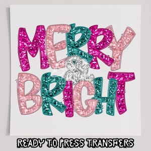 May include: A festive design with the words "MERRY & BRIGHT" in pink, teal, and light pink glitter lettering. The phrase "READY TO PRESS TRANSFERS" is printed in black at the bottom. Perfect for holiday crafts.