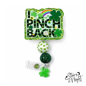 May include: A St. Patrick's Day themed retractable badge reel with the text "I PINCH BACK". The badge reel has a green glitter border, a white and green polka dot bead, and a green glitter shamrock charm.