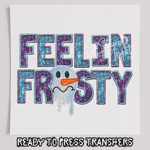 Puede incluir: Un fondo blanco presenta la frase "FEELIN FROSTY" en letras brillantes de color turquesa y morado, con un gráfico de un muñeco de nieve derritiéndose. Debajo, el texto "READY TO PRESS TRANSFERS" se muestra en una fuente audaz y estilizada.