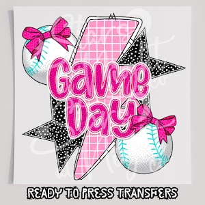 May include: A pink and black graphic design with the text "Game Day" and two baseballs with pink bows.