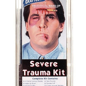 Puede incluir: Un kit de maquillaje teatral llamado "Severe Trauma Kit" con una imagen gr&aacute;fica de un hombre con una herida sangrante en la frente y un ojo morado. El kit incluye maquillaje, esponjas e instrucciones.