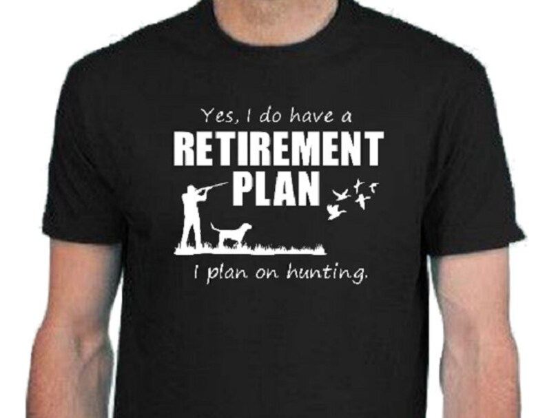 May include: Black t-shirt with white text that reads "Yes, I do have a RETIREMENT PLAN I plan on hunting."  A silhouette of a person hunting with a dog is shown above the text.