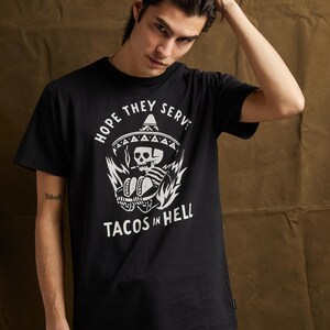 Peut inclure: T-shirt noir avec un imprim&eacute; blanc d'un squelette portant un sombrero et tenant des tacos. Le texte "Hope they serve tacos in hell" est imprim&eacute; sous l'imprim&eacute;.