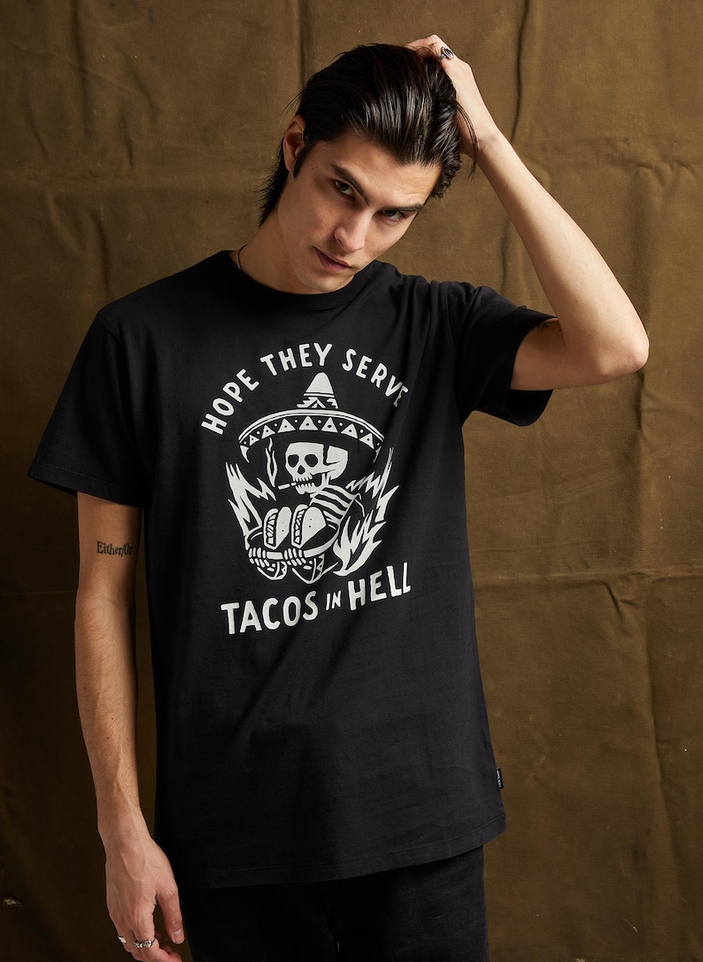 Peut inclure: T-shirt noir avec un imprim&eacute; blanc d'un squelette portant un sombrero et tenant des tacos. Le texte "Hope they serve tacos in hell" est imprim&eacute; sous l'imprim&eacute;.