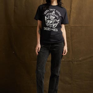 Peut inclure: T-shirt noir avec un graphique blanc d'un squelette portant un sombrero et tenant des tacos. Le texte "Hope they serve tacos in hell" est imprim&eacute; sous le graphique.