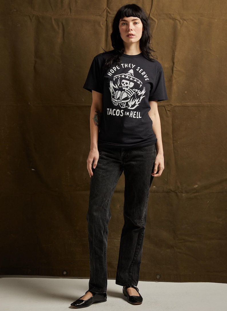 Peut inclure: T-shirt noir avec un graphique blanc d'un squelette portant un sombrero et tenant des tacos. Le texte "Hope they serve tacos in hell" est imprim&eacute; sous le graphique.