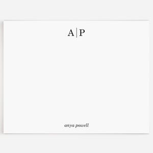 May include: A white card with the initials "A|P" and the name "anya powell" printed in black.