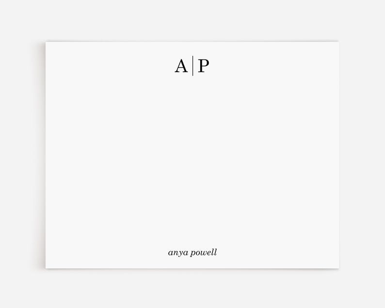 May include: A white card with the initials "A|P" and the name "anya powell" printed in black.