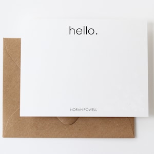 May include: A white card with the word "hello." printed in black. The card is folded in half and has a brown envelope.