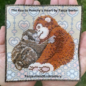 May include: A square beaded tapestry titled The Key to Punchy's Heart by Tanja Berlin, featuring a brown monkey holding a dark brown object against a background of light-colored hearts. The text TanjasHandEmbroidery is printed at the bottom.