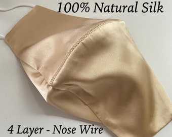 May include: A gold-colored, four-layer face mask made of 100% natural silk. The mask has a nose wire and is available in women's and men's sizes.  "S5 - Gold" and "100% Natural Silk" are printed on the mask.