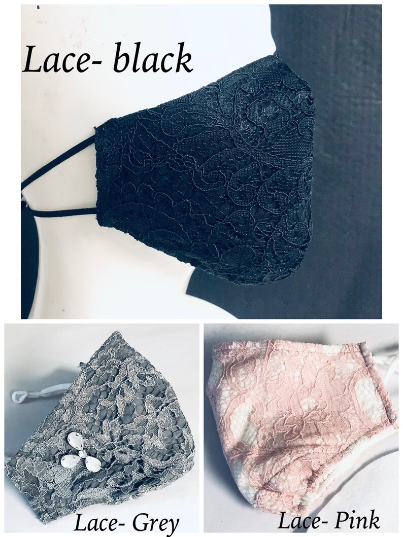 May include: Three face masks in black, grey, and pink lace. The black mask is displayed at an angle. The grey mask has a decorative jewel. The pink mask has a white lining. Text on the image reads "Lace- black", "Lace- Grey", and "Lace- Pink".