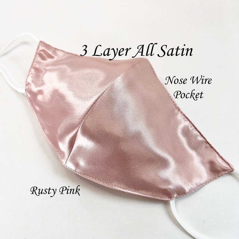 Puede incluir: Una mascarilla facial de sat&eacute;n rosa oxidado con tres capas y un bolsillo para el alambre de la nariz. La mascarilla est&aacute; hecha de tela de sat&eacute;n suave y lisa.
