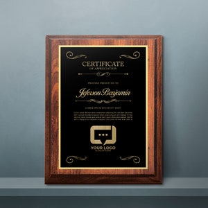 May include: A wooden plaque with a black background and gold lettering. The plaque reads "Certificate of Appreciation" and "Proudly Presented to Jeferson Benjamin". There is a gold logo with a speech bubble and the text "Your Logo Slogan Here".