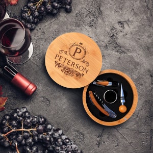 May include: A wooden box with a personalized engraved lid that says "P. PETERSON" with a crown above the letter P. The box contains a wine opener, a bottle stopper, and a foil cutter.