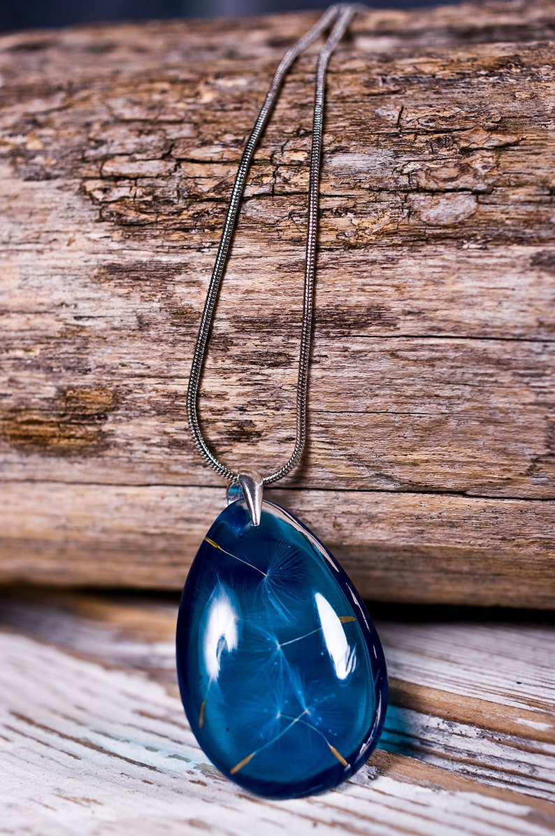 Delicate blue resin pendant with real dandelion seeds: