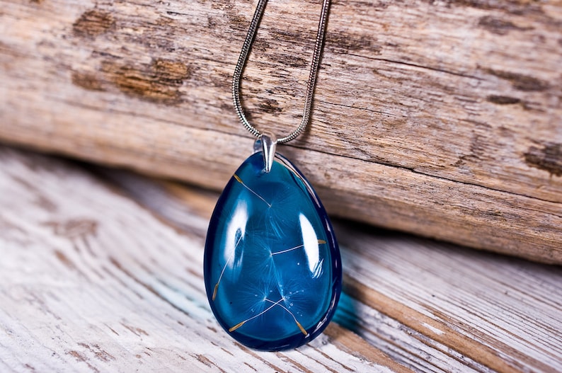 Delicate blue resin pendant with real dandelion seeds: