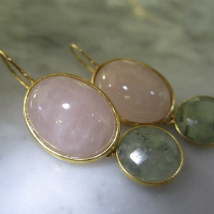 May include: Gold earrings with oval shaped pink and green stones.