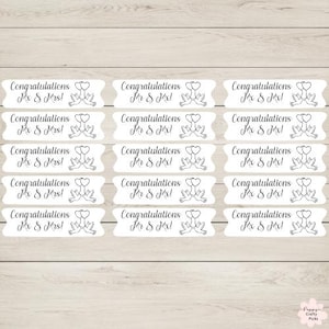 May include: White labels with the text "Congratulations Mr & Mrs!" in elegant script. Each label features a pair of doves holding hearts. The labels are arranged on a light wood-grain surface.