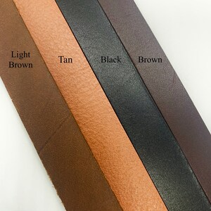 May include: Four leather strips in different colors: light brown, tan, black, and brown. The strips are arranged diagonally from top left to bottom right.