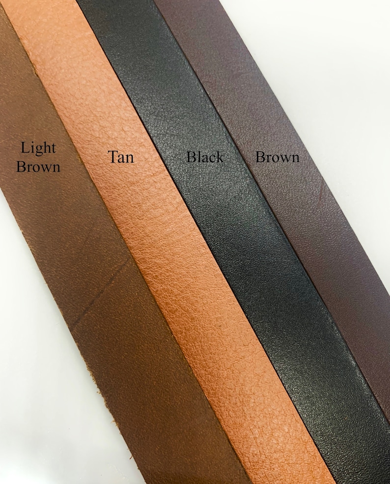 May include: Four leather strips in different colors: light brown, tan, black, and brown. The strips are arranged diagonally from top left to bottom right.