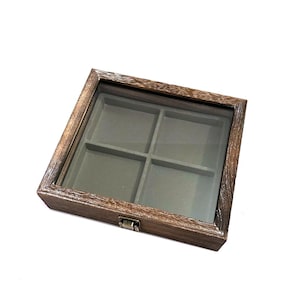 May include: A wooden display box with a glass top and four compartments lined with gray felt. The box has a brass latch.