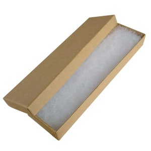 May include: An open, rectangular cardboard jewelry box with a lid. The interior is lined with white, fluffy padding. The box is a light brown color and is empty, ready for use.