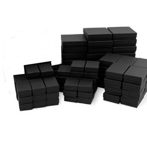 May include: A large quantity of black cardboard boxes stacked in a pile. The boxes are all the same size and shape, and they are arranged in a random pattern.