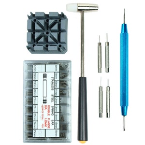 May include: A watch band tool kit with a variety of spring bars, a hammer, a watch band holder, and a pin pusher. The spring bars are organized in a clear plastic box with sizes ranging from 8mm to 25mm. The kit is ideal for watch repair and maintenance.