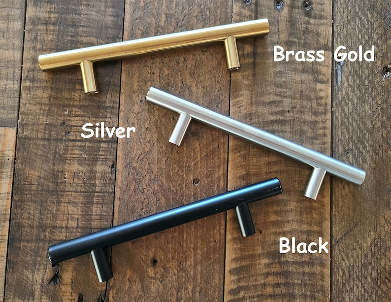 Puede incluir: Tres tiradores de armario en diferentes acabados: oro lat&oacute;n, plata y negro. Los tiradores son todos del mismo tama&ntilde;o y forma, con un dise&ntilde;o simple y moderno.