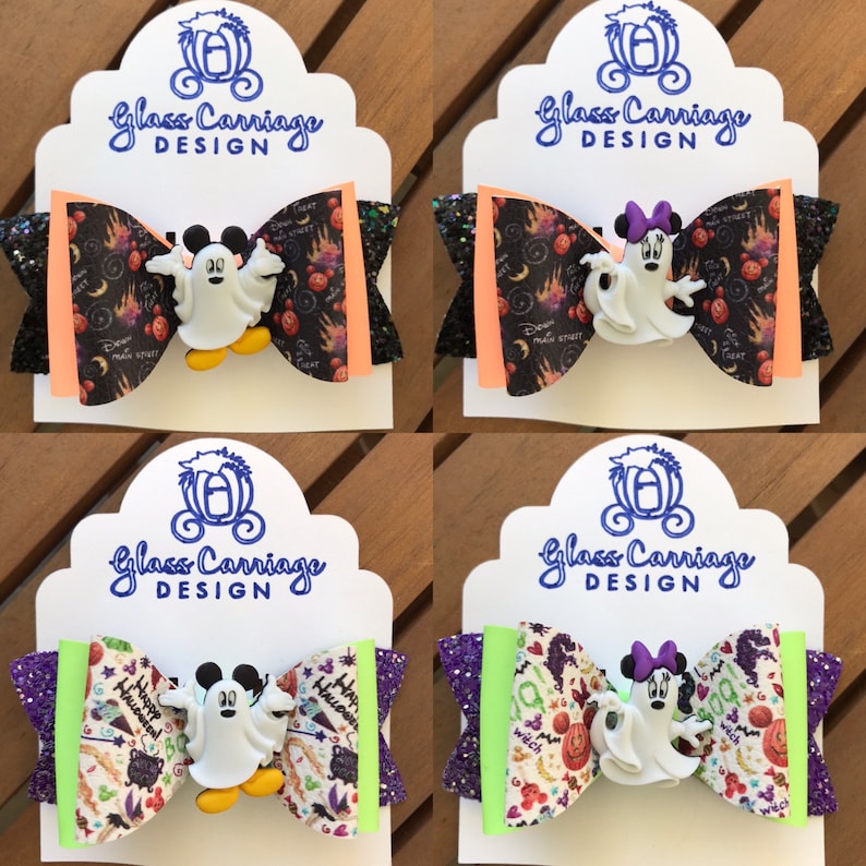 May include: Four Halloween-themed hair bows featuring a ghost Mickey Mouse and Minnie Mouse character. The bows are made with black, orange, purple, and green glitter fabric and feature a variety of Halloween-themed patterns.