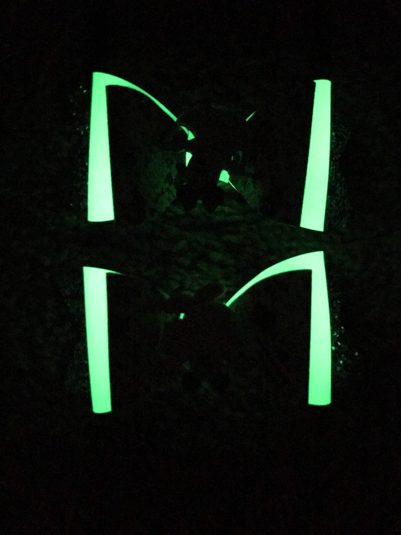 May include: Two pairs of glow-in-the-dark green shoelaces. The shoelaces are tied in a bow and are illuminated in the dark.