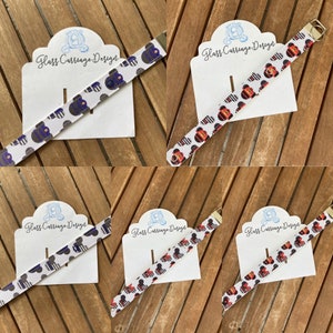 Peut inclure: Cinq bracelets blancs avec des motifs Mickey Mouse noirs et rouges, et un bracelet blanc avec des motifs Mickey Mouse noirs et bleus. Les bracelets sont présentés sur des cartes blanches avec le texte "Glass Carriage Design".