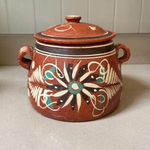 May include: A handmade wooden sign with the text "Welcome" in a playful font. The sign is painted white with a distressed finish, and features a decorative floral design in shades of pink and green. It is designed for indoor or outdoor use.