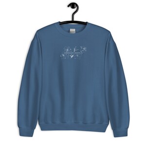 May include: A blue sweatshirt with a white floral design and the text "[INHALES DEEPLY]" printed on the front.