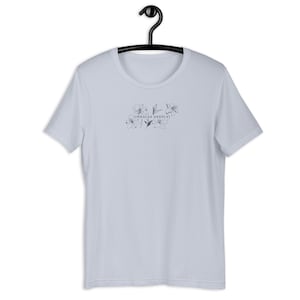 May include: A light blue t-shirt with a floral design and the text "[inhales deeply]" printed on the front.