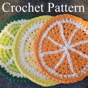 May include: Three crocheted coasters shaped like citrus fruit slices. The coasters are in green, yellow, and orange, with white detailing. The image includes the text "Crochet Pattern" at the top.