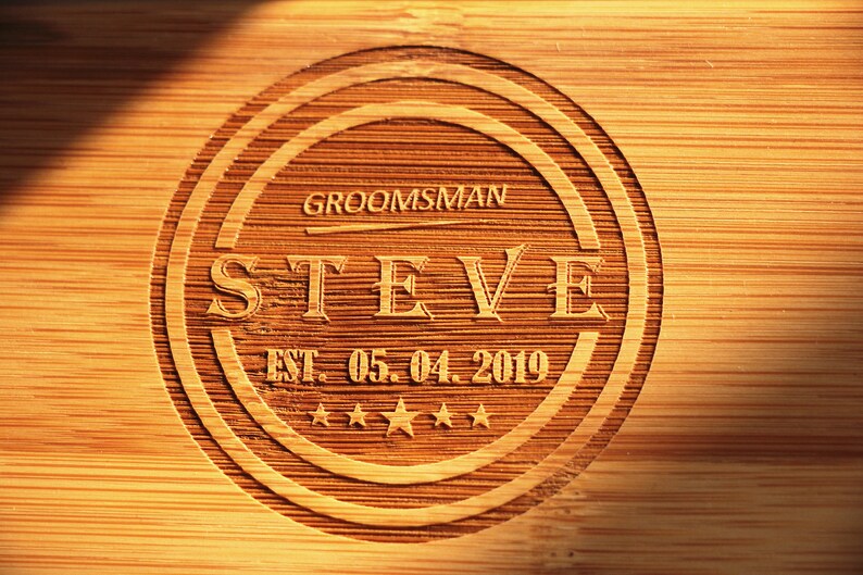 May include: A wooden plaque with a circular design, featuring the text "GROOMSMAN STEVE EST. 05.04.2019" and five stars.