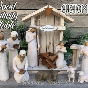 May include: A white wooden nativity stable with a white painted roof and a rustic woodgrain finish. The stable includes a manger, a shepherd, a Mary and Joseph figurine, and three wise men. The stable is decorated with a star on the roof and a sign that reads "The Peterson's".