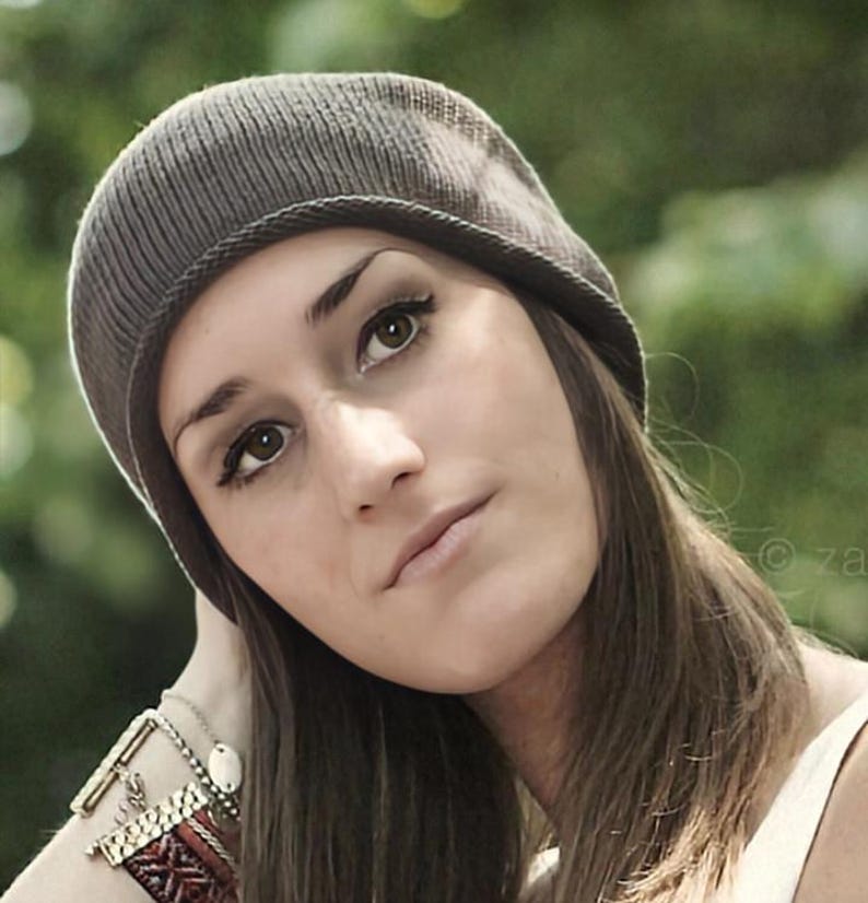 May include: A dark gray knit beanie with a ribbed texture and a folded brim. The beanie is constructed from a fine-gauge knit fabric, featuring a rounded crown that fits closely to the head, providing a simple and functional head covering.
