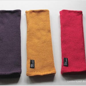May include: Three knitted fabric wrist warmers in purple, yellow, and red. Each warmer has a small black label with white text.