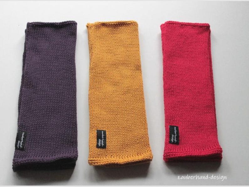 May include: Three knitted fabric wrist warmers in purple, yellow, and red. Each warmer has a small black label with white text.
