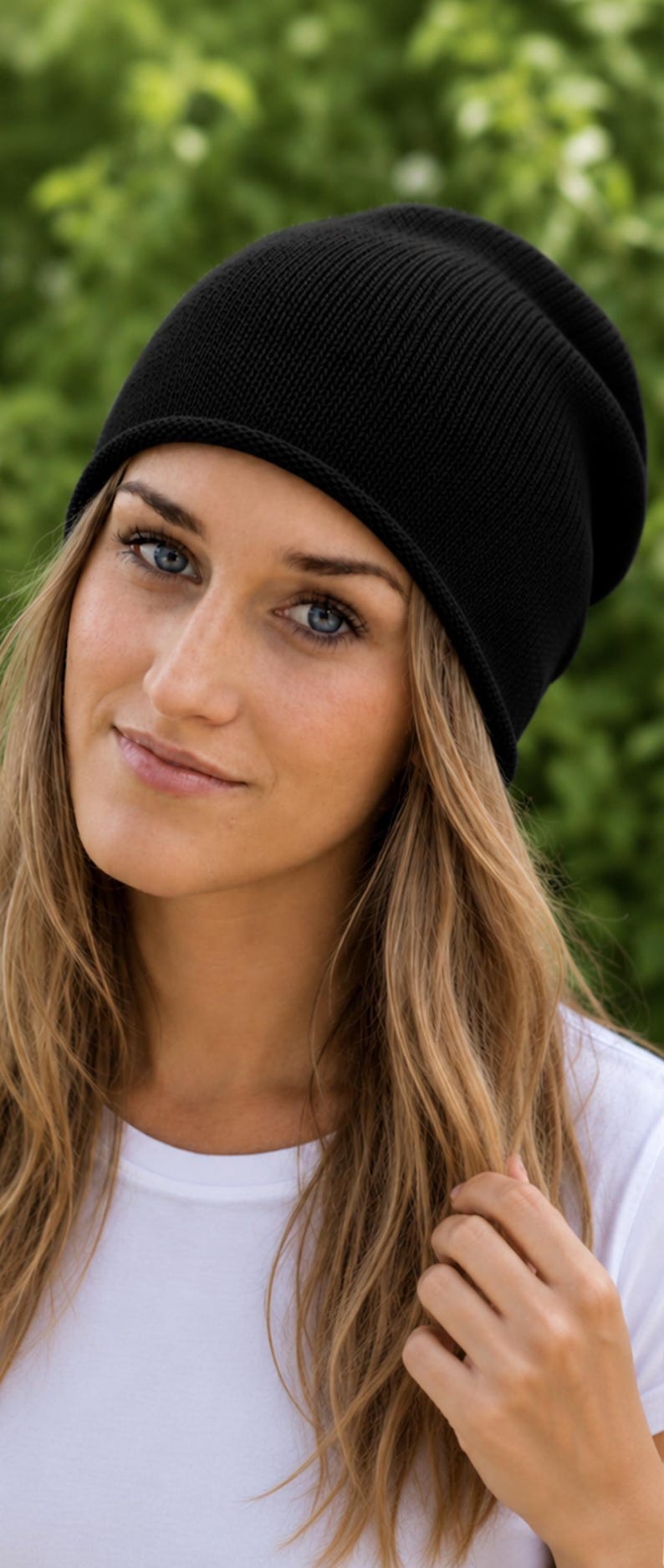 May include: A solid black knit beanie with a simple, rounded crown and a clean, finished edge. The hat is constructed from a fine-gauge knit fabric, providing a smooth, uniform texture that fits snugly around the head in a classic, versatile style.