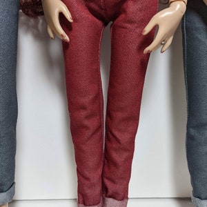 May include: A pair of red denim jeans with a cuffed hem.