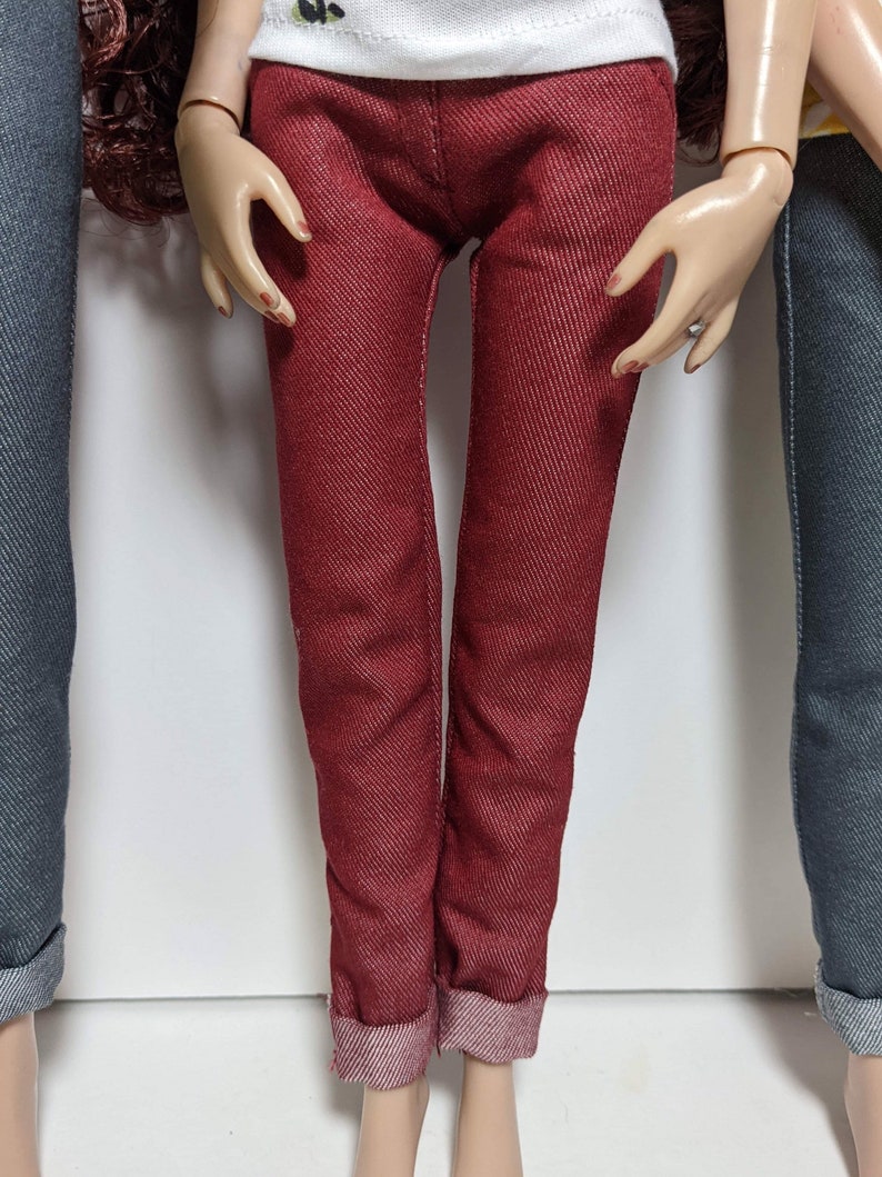May include: A pair of red denim jeans with a cuffed hem.