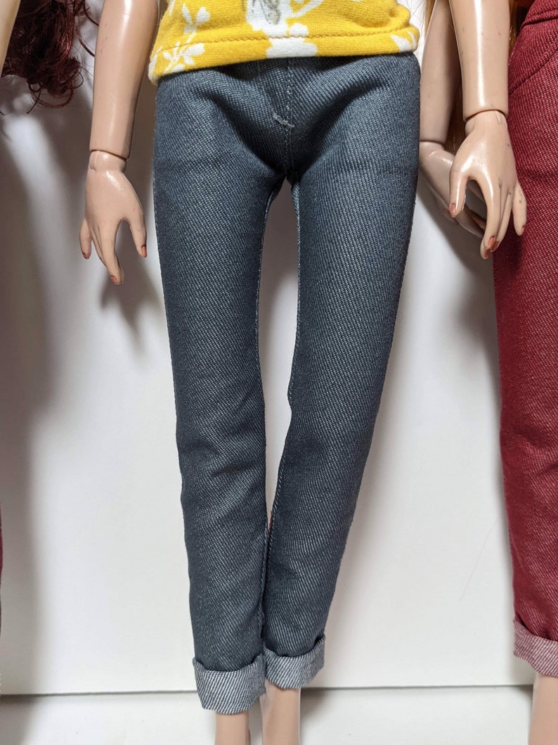 May include: A pair of dark blue denim jeans with cuffed hems.