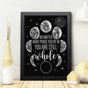 May include: Black and white printable wall art featuring a quote about phases of life and a moon design. The quote reads "No matter what phase you're in you are still whole".